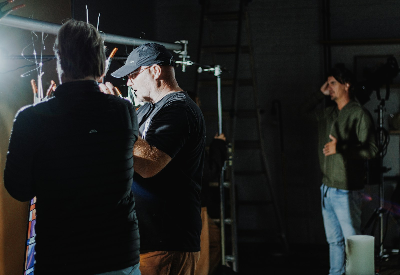 Film crew gathered around the camera on a low-light set, working under schedule pressure